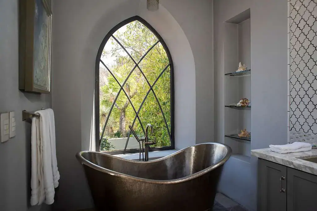 Casa Sereno, bathroom with a copper soaking tub and a pointed arch window, San Miguel de Allende