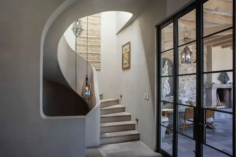 Casa Sereno, spiral staircase beside black steel doors, San Miguel de Allende