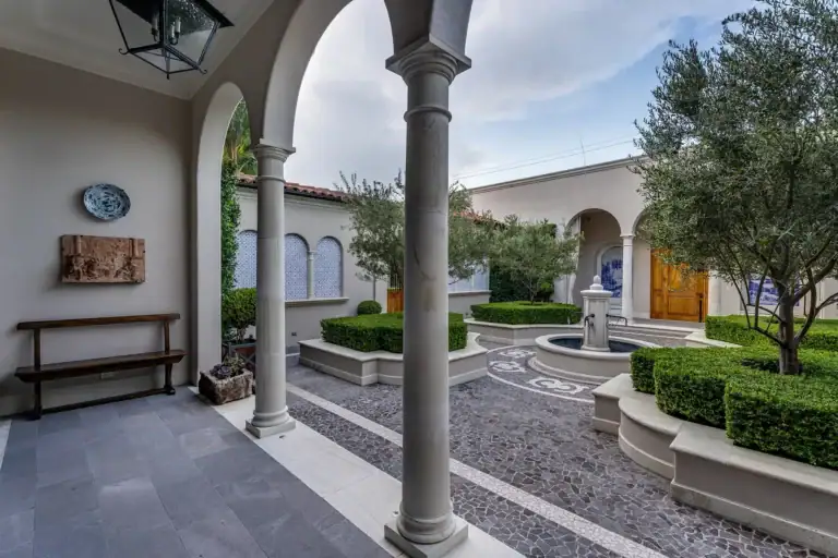 Casa Sienna, covered arcade with stone columns looking out to the courtyard fountain, San Miguel de Allende