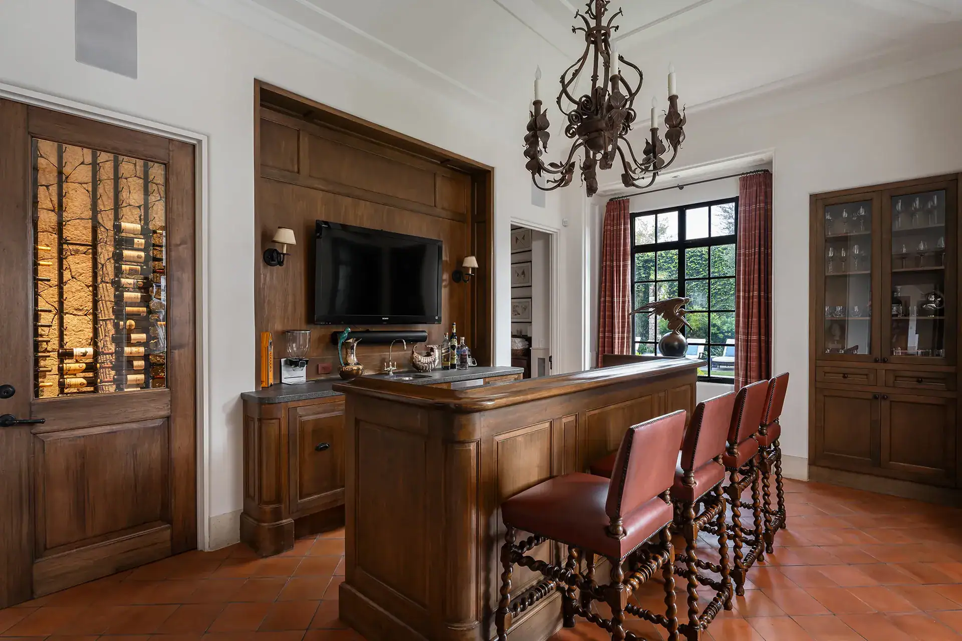 Casa Sienna, wood-paneled bar with leather stools and a lit wine cabinet, San Miguel de Allende