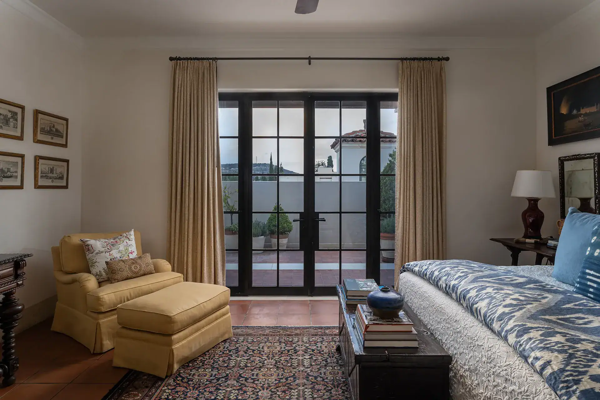 Casa Sienna, bedroom sitting area with a yellow armchair and glass doors onto a terrace, San Miguel de Allende