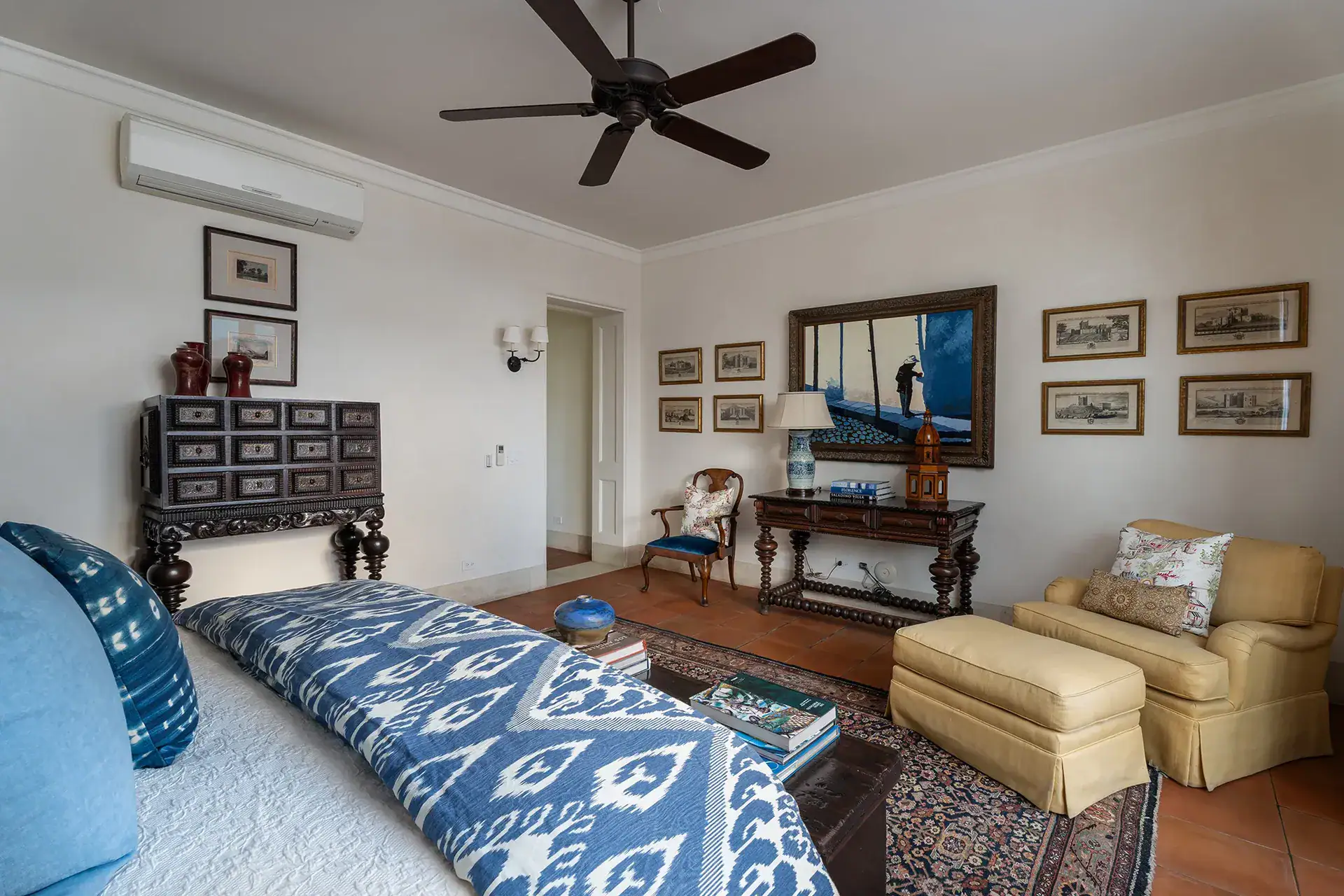 Casa Sienna, bedroom with a blue ikat bedspread, antique chest and framed prints, San Miguel de Allende