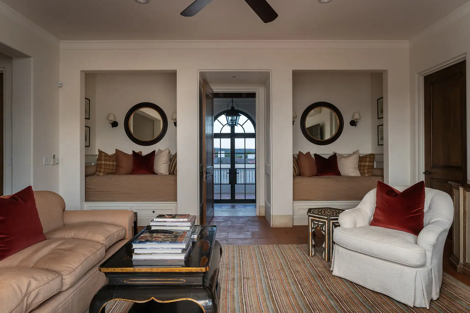 Casa Sienna, sitting room with a leather sofa, white armchair and built-in window seats, San Miguel de Allende