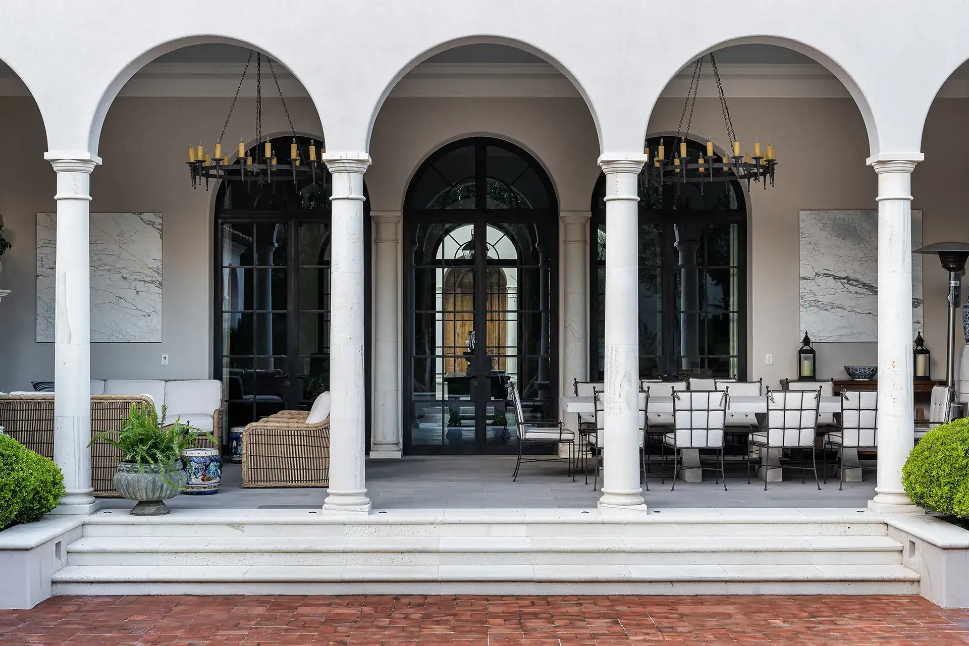 Casa Sienna, arcaded loggia with a long dining table and a lounge area under chandeliers, San Miguel de Allende