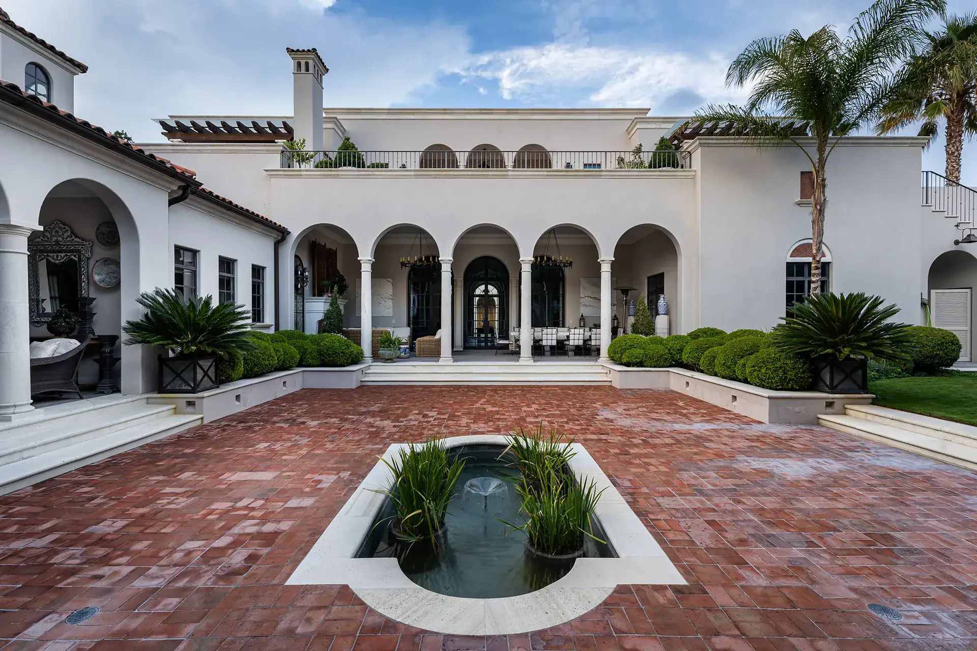 Casa Sienna, brick terrace with a lily pond and an arcaded facade with a rooftop balcony, San Miguel de Allende