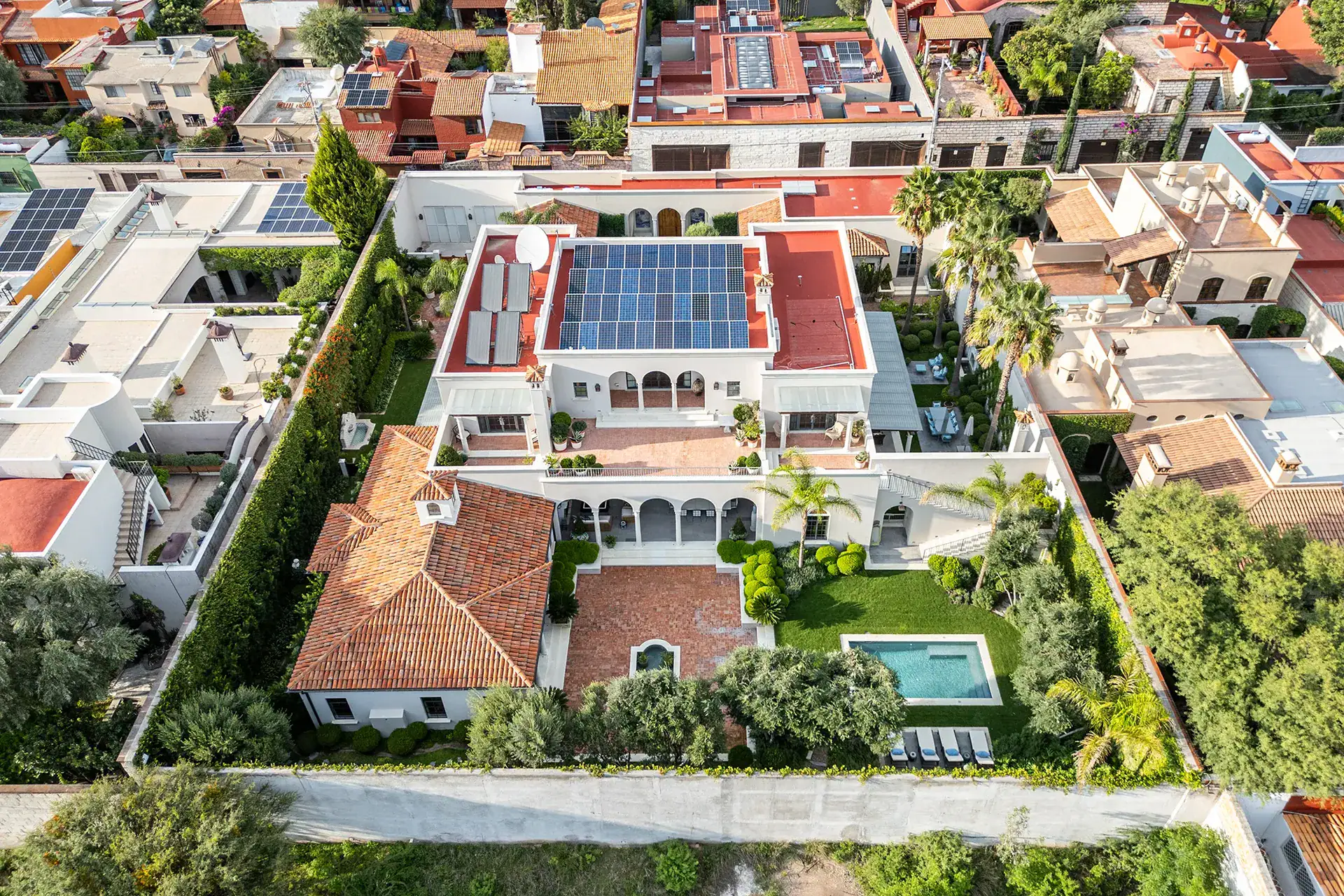 Casa Sienna, aerial view of the house with rooftop solar panels, pool and surrounding neighborhood, San Miguel de Allende