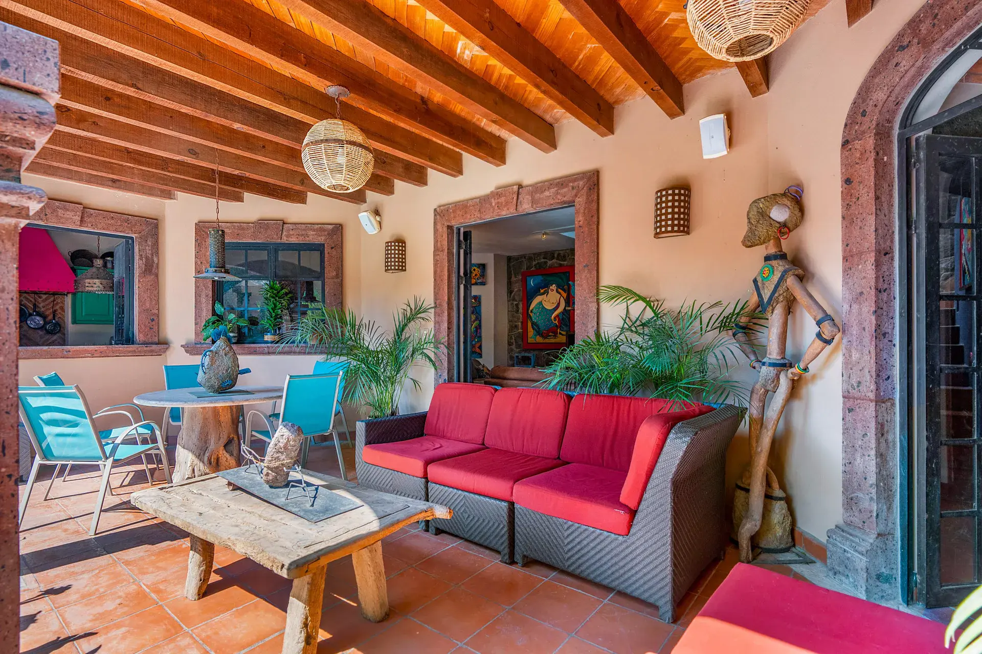Casa Sirena, arcade lounge with a red sofa, turquoise chairs and a glass table with a lantern pendant, San Miguel de Allende