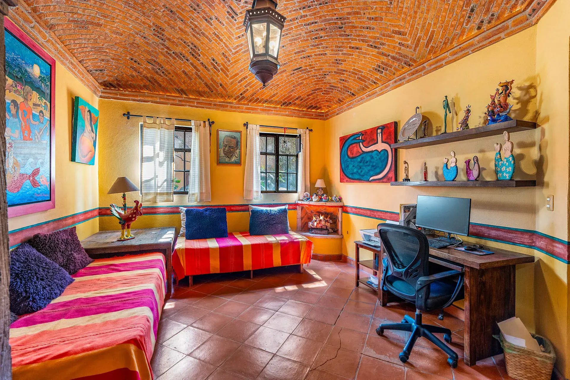 Casa Sirena, office with a brick vaulted ceiling, a striped daybed, a desk, a computer and paintings, San Miguel de Allende
