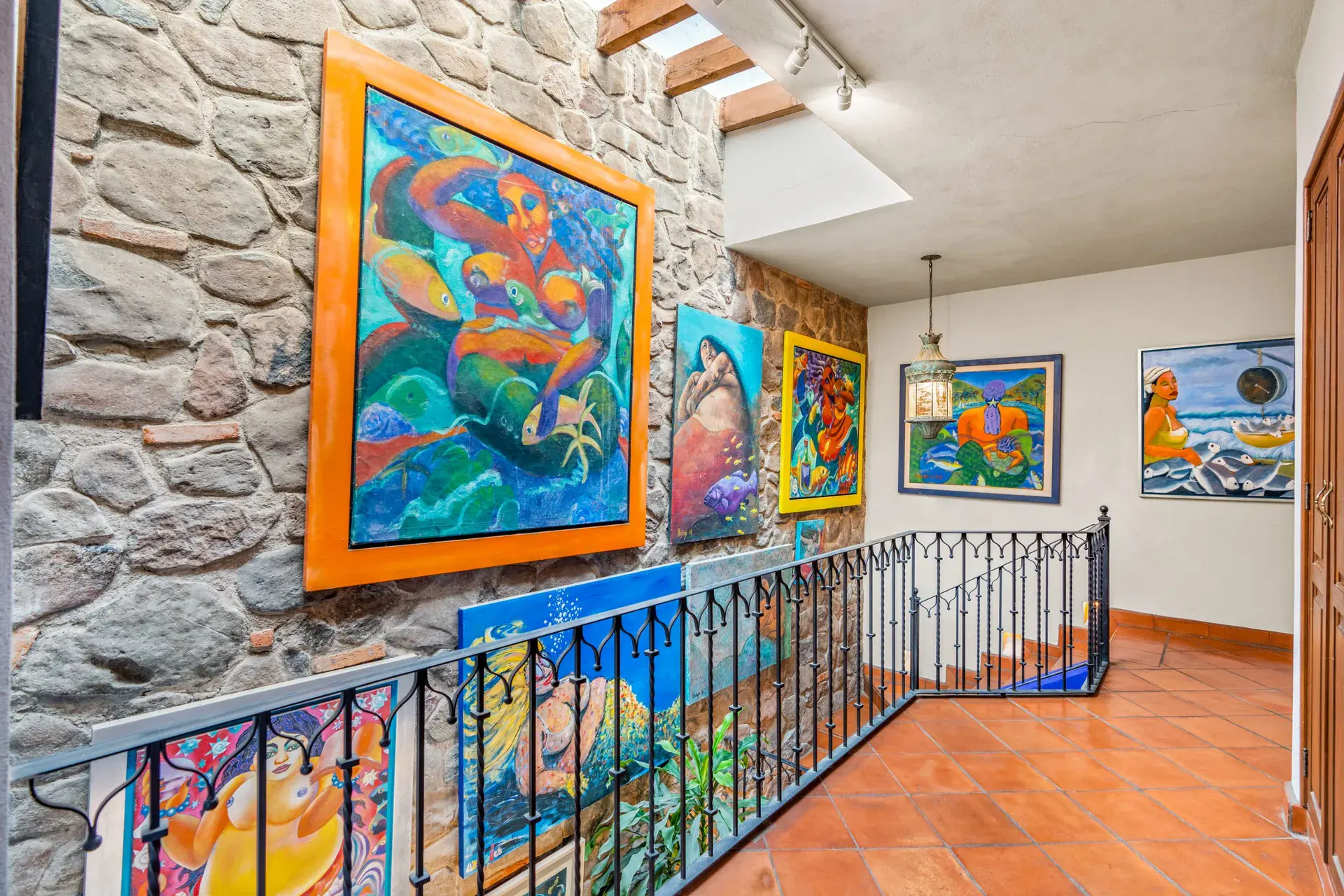 Casa Sirena, landing with a stone wall, an iron railing and a mermaid painting, San Miguel de Allende