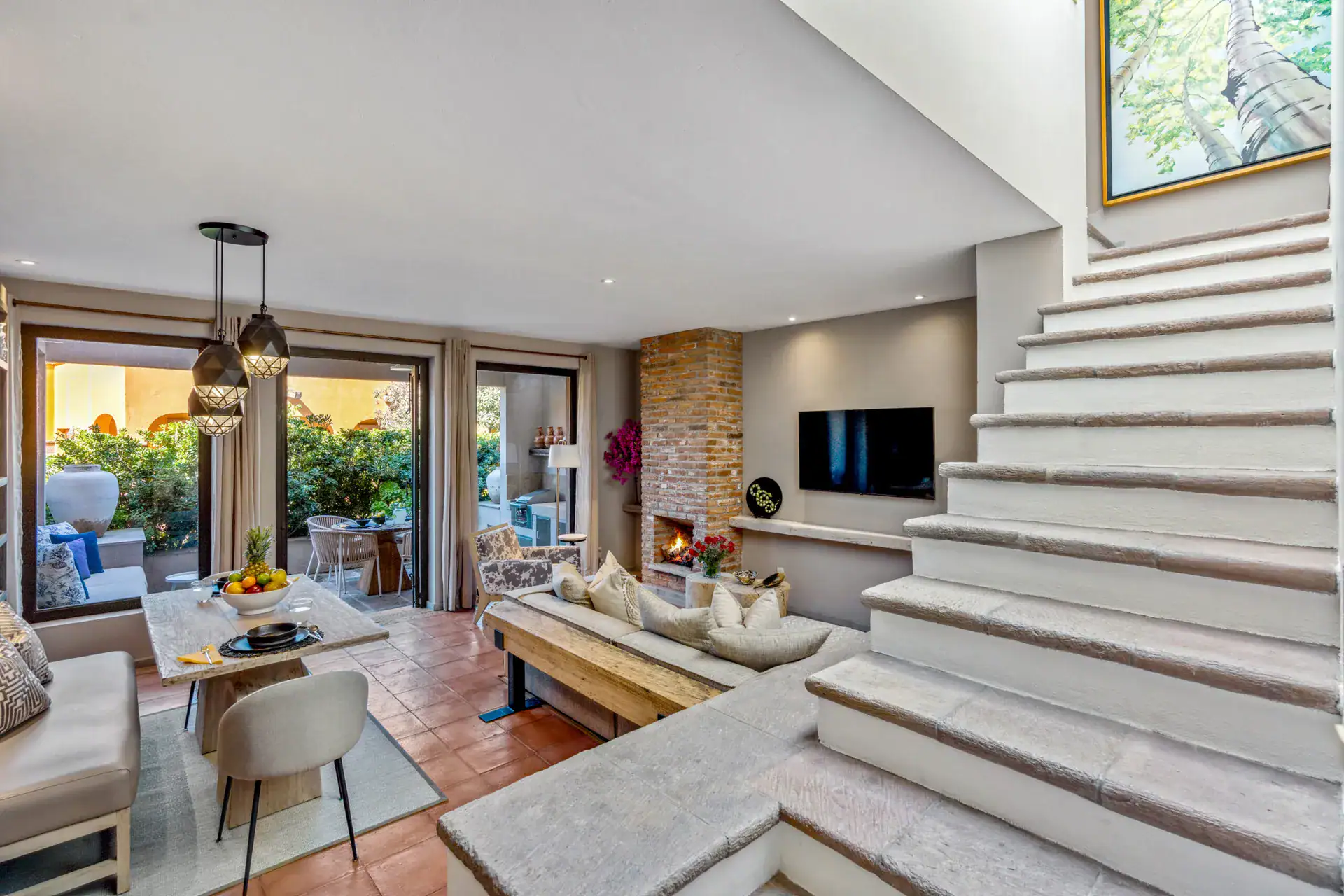 Casa Tequila, living and dining area beside a white staircase and a fireplace, San Miguel de Allende