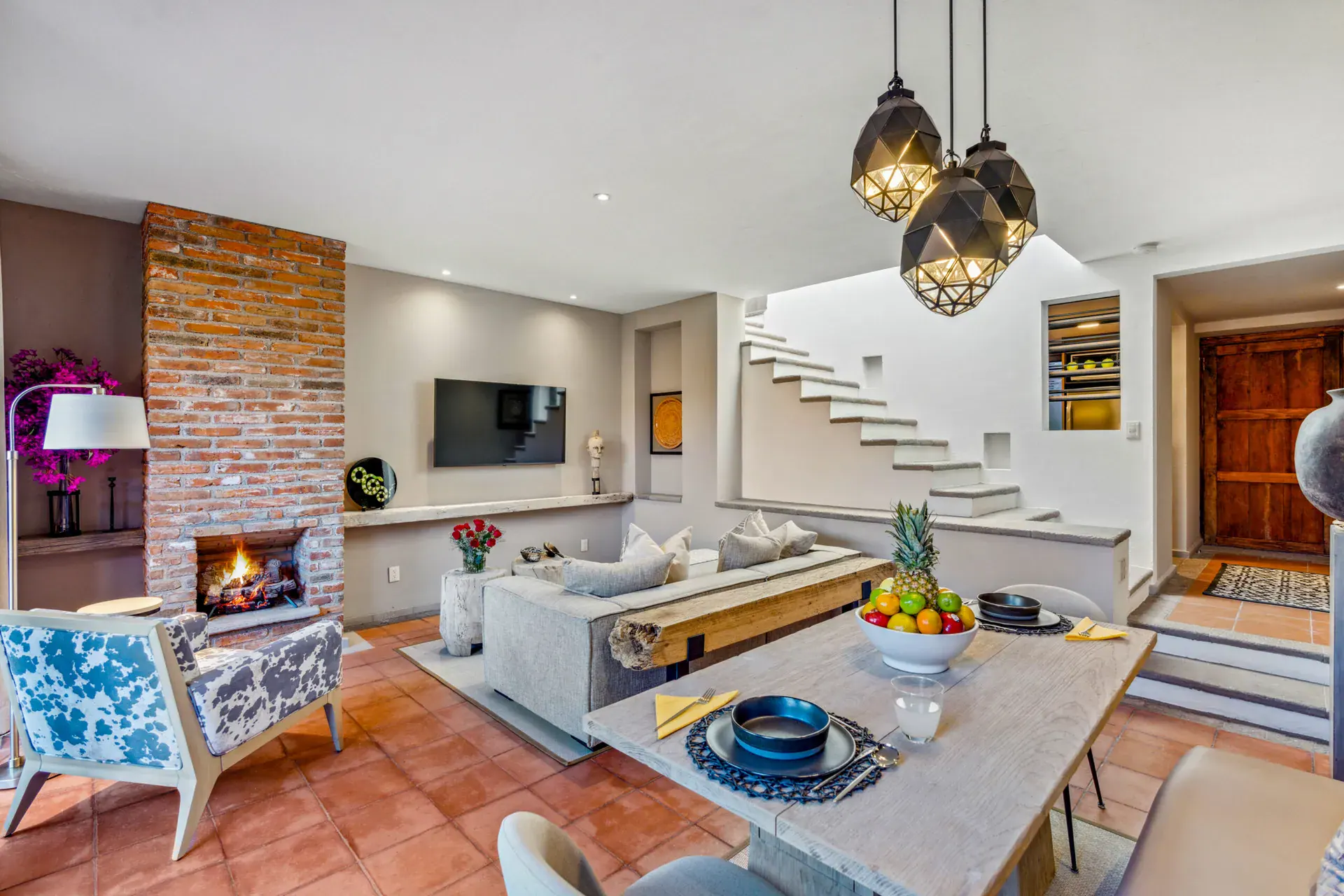 Casa Tequila, living room with a brick fireplace wall and a white sofa, San Miguel de Allende