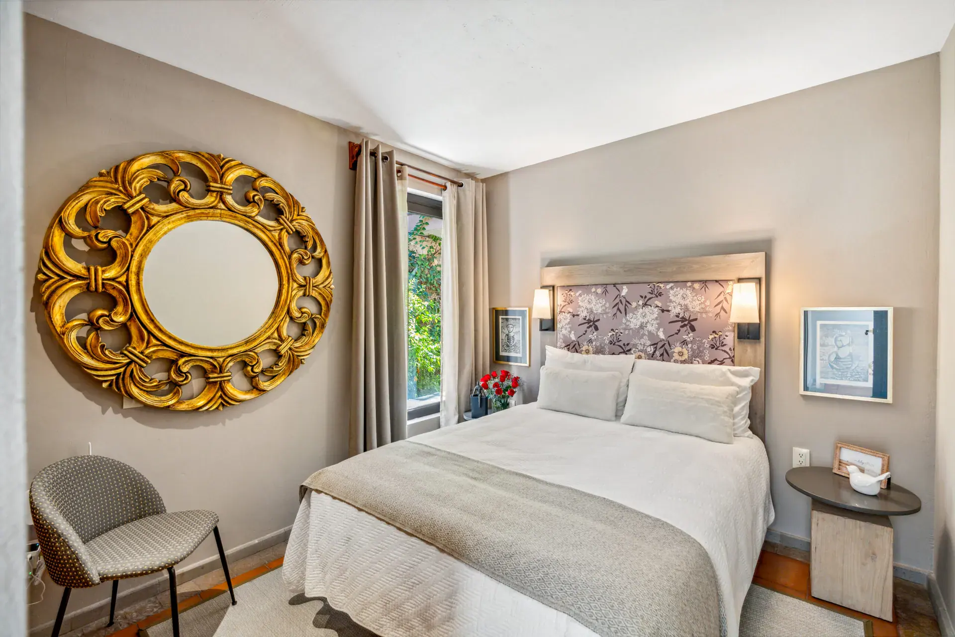 Casa Tequila, bedroom with a gold mirror, a floral headboard and a tall window, San Miguel de Allende