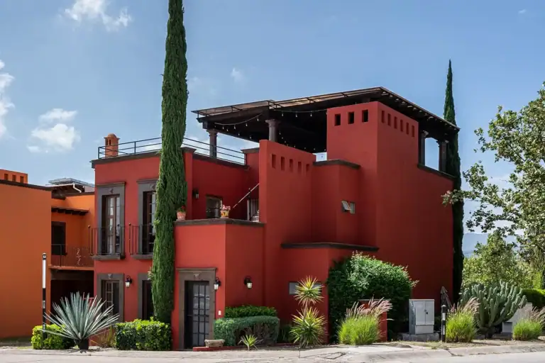 Casa Texican, red stucco house with a roof terrace and a cypress tree, San Miguel de Allende