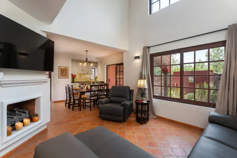 Casa Texican, living room with a gray sectional and a white fireplace, San Miguel de Allende