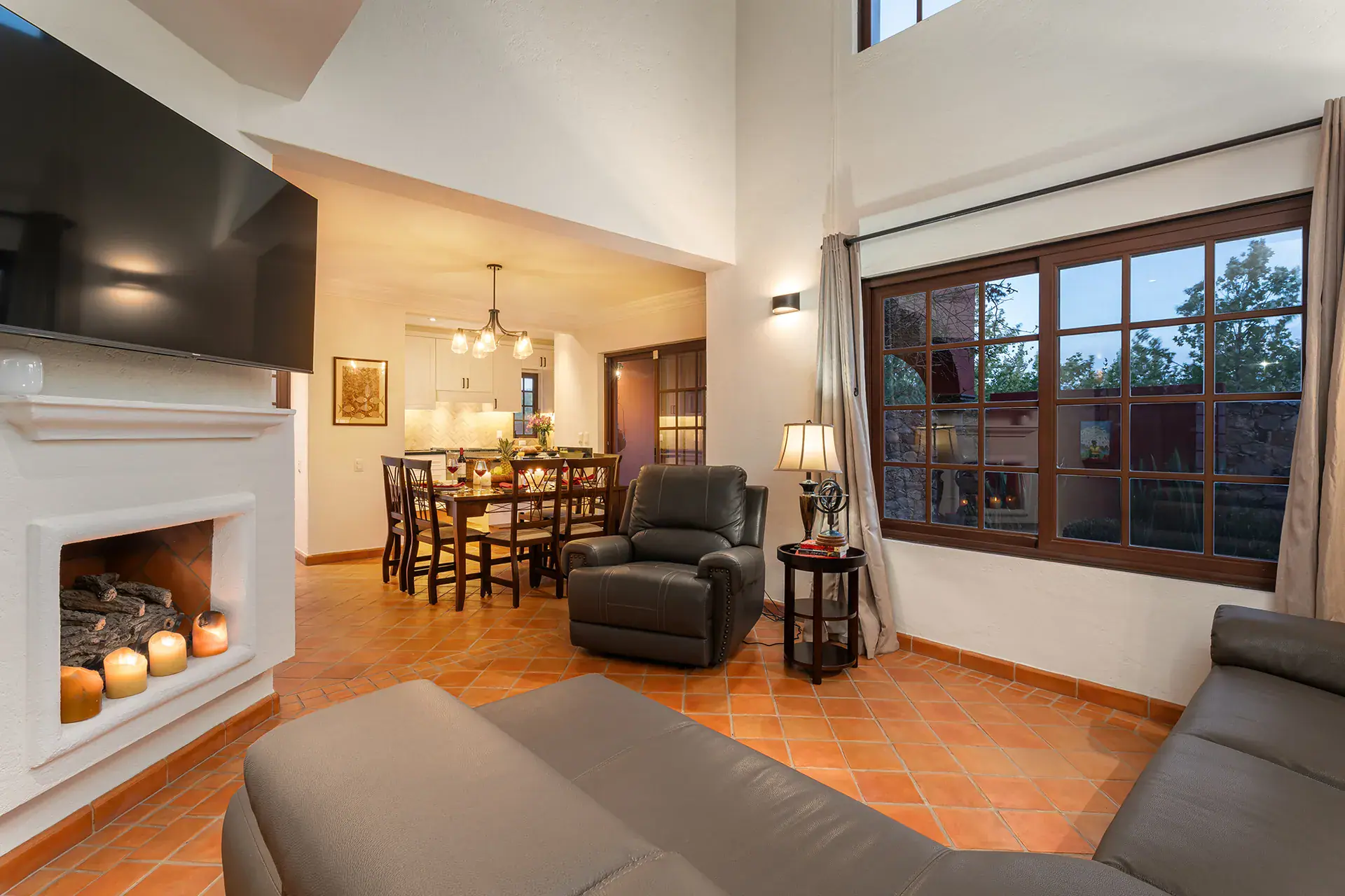Casa Texican, dining and living area with a large window and a fireplace, San Miguel de Allende