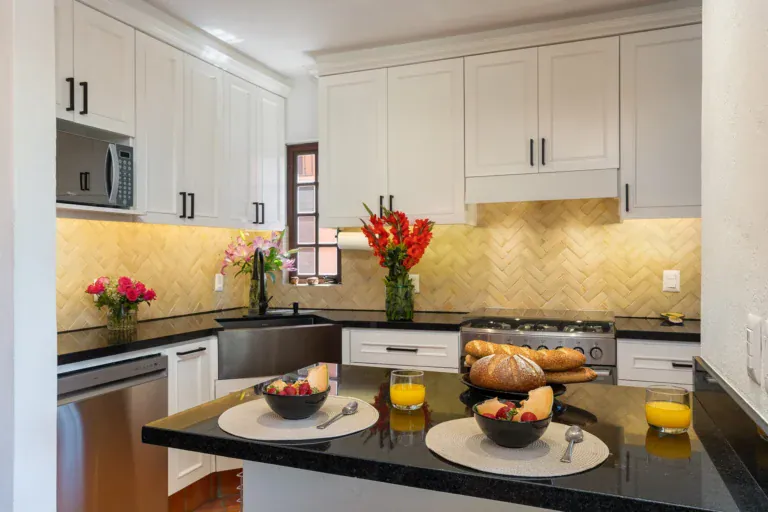 Casa Texican, kitchen with white cabinets, black counters and a farmhouse sink, San Miguel de Allende