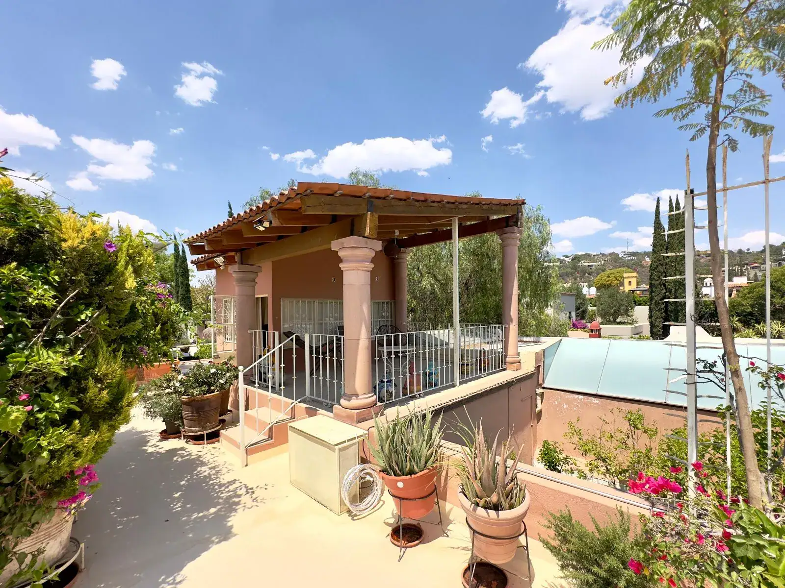 Casa Trebol, roof terrace with a covered pavilion, a metal railing, potted agaves and a glass skylight, San Miguel de Allende