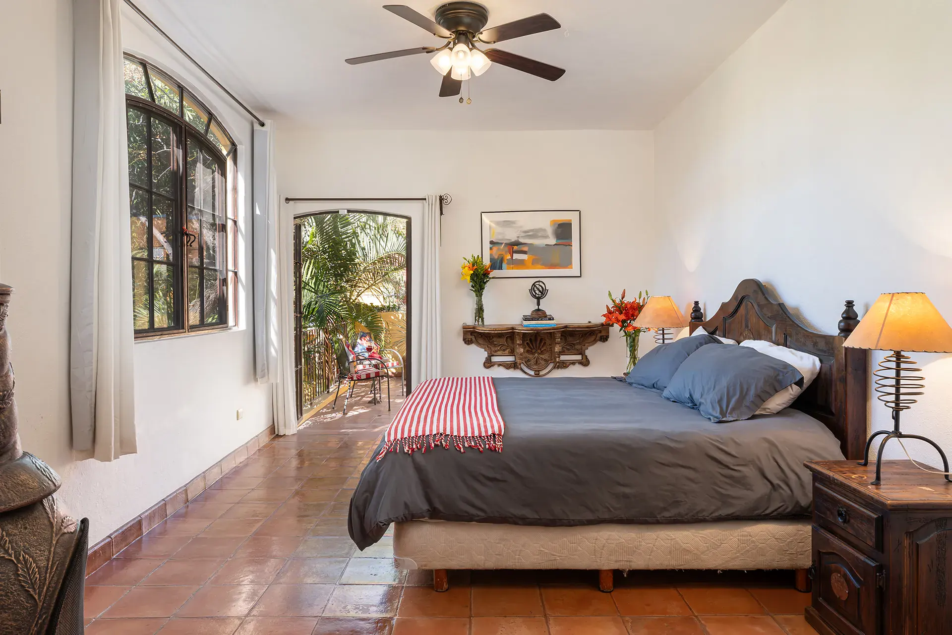 Casa Victoria, bedroom with a carved headboard and a red striped runner, San Miguel de Allende