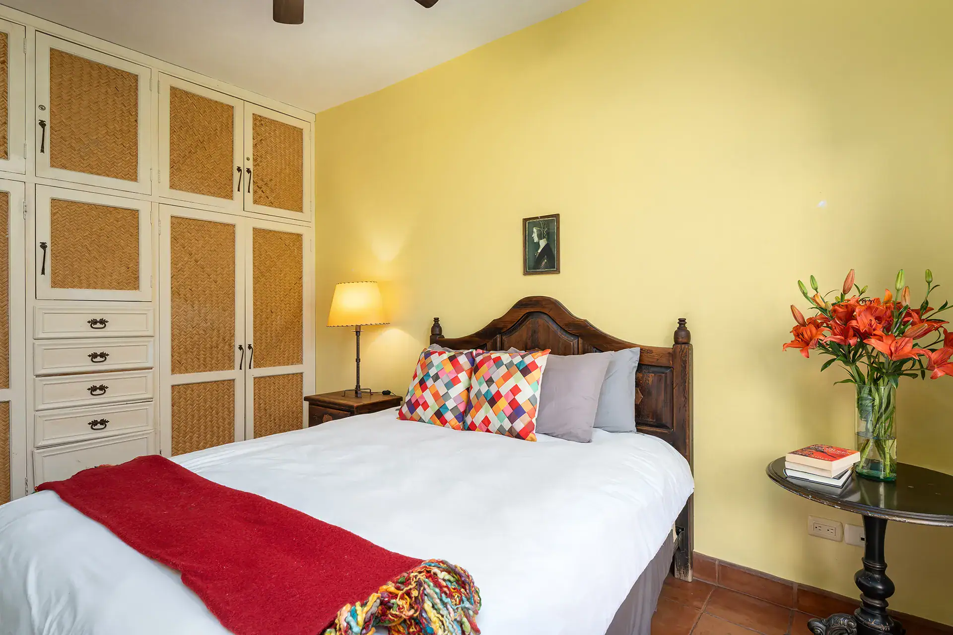 Casa Victoria, yellow bedroom with a carved bed and a built-in wardrobe, San Miguel de Allende