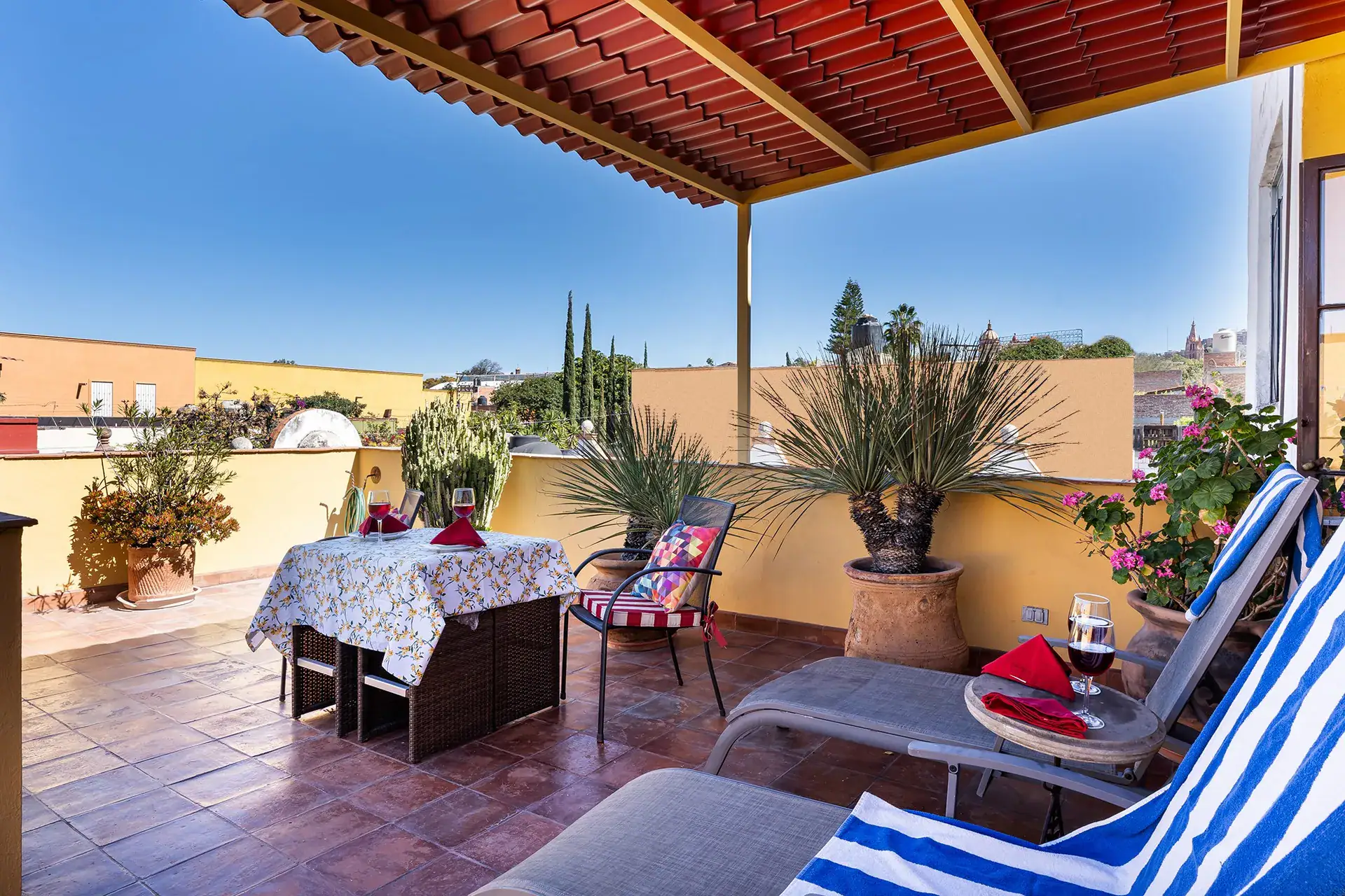 Casa Victoria, rooftop terrace with striped chaise lounges and a covered seating area, San Miguel de Allende