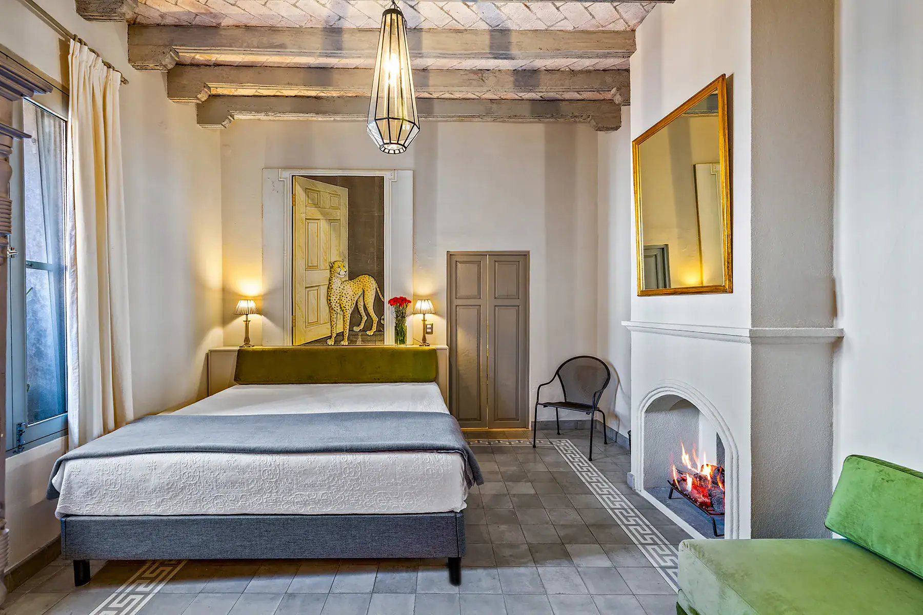 Casa White Magnolias, bedroom with a green headboard, fireplace and a framed gold mirror, San Miguel de Allende