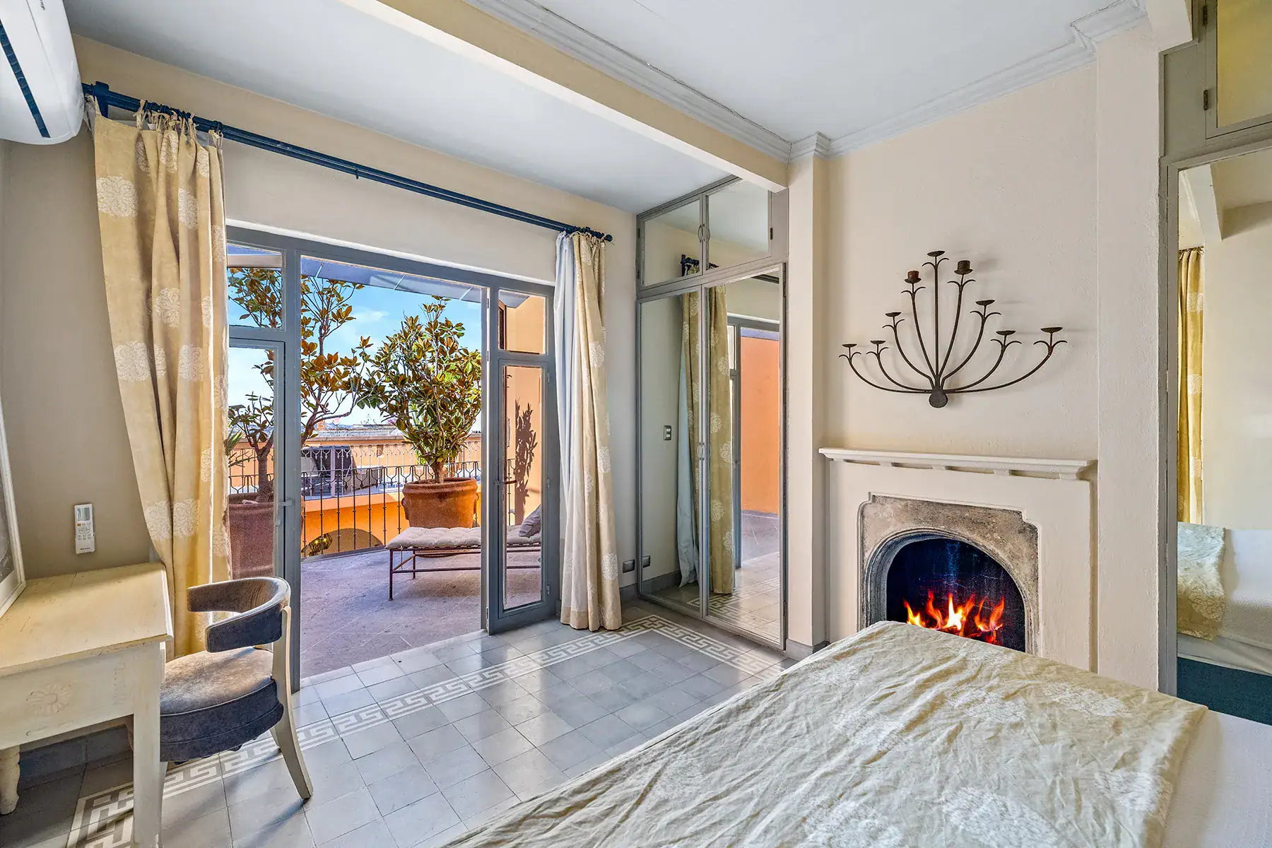 Casa White Magnolias, bedroom with a fireplace and French doors opening to a terrace, San Miguel de Allende