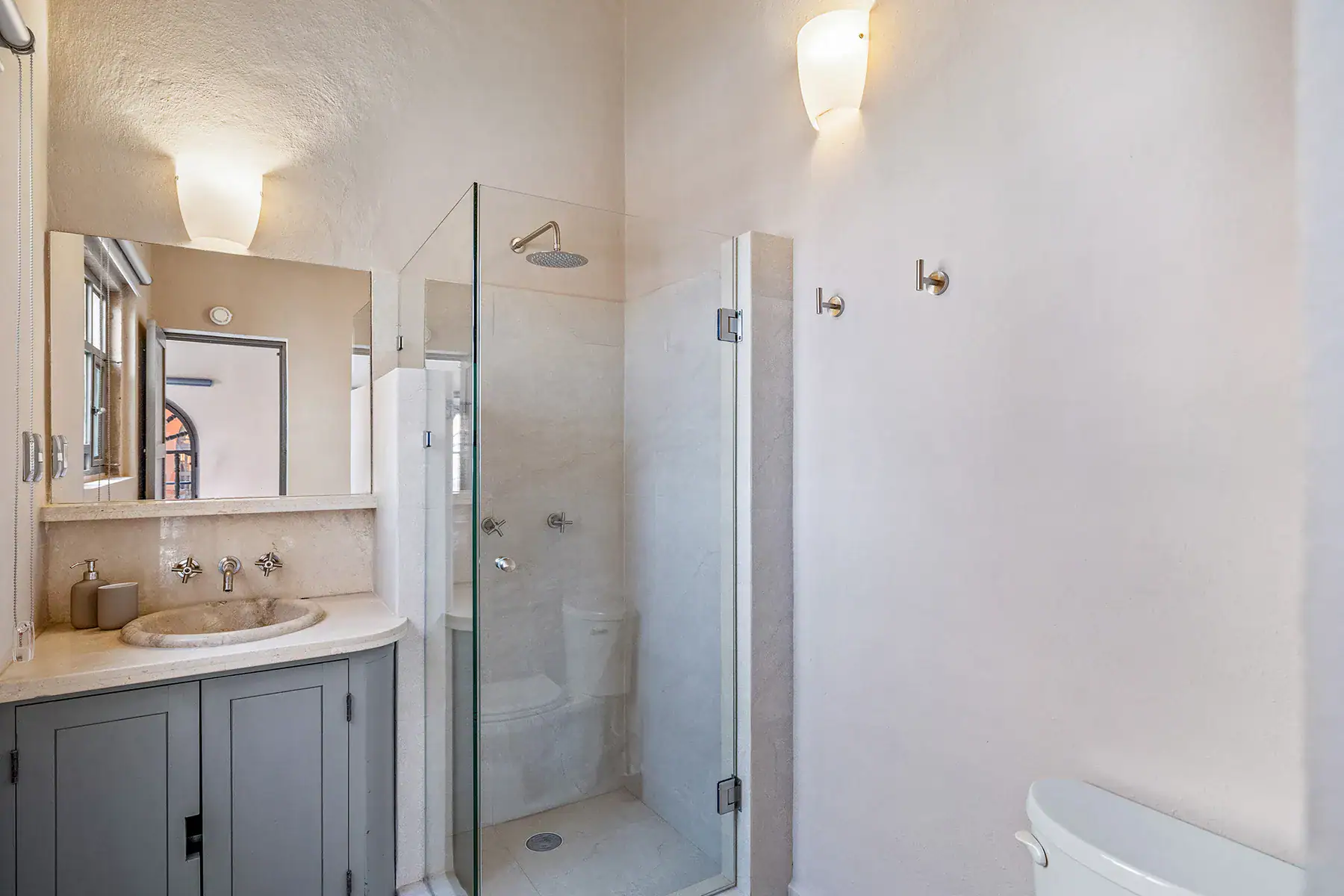 Casa White Magnolias, bathroom with a stone sink, glass shower and a gray vanity, San Miguel de Allende