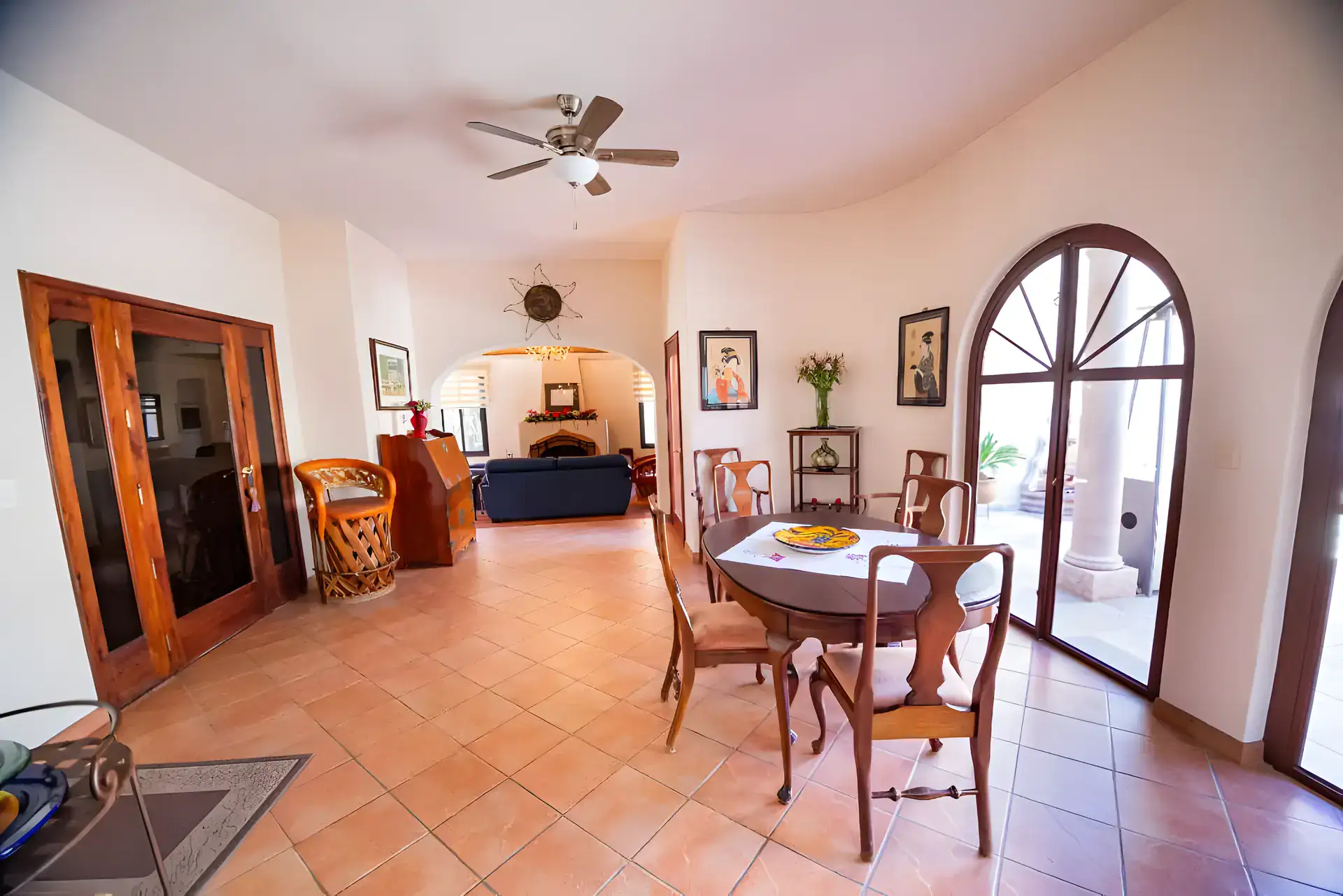 Casa Winston, dining table by arched French doors, with a living room and fireplace beyond, San Miguel de Allende