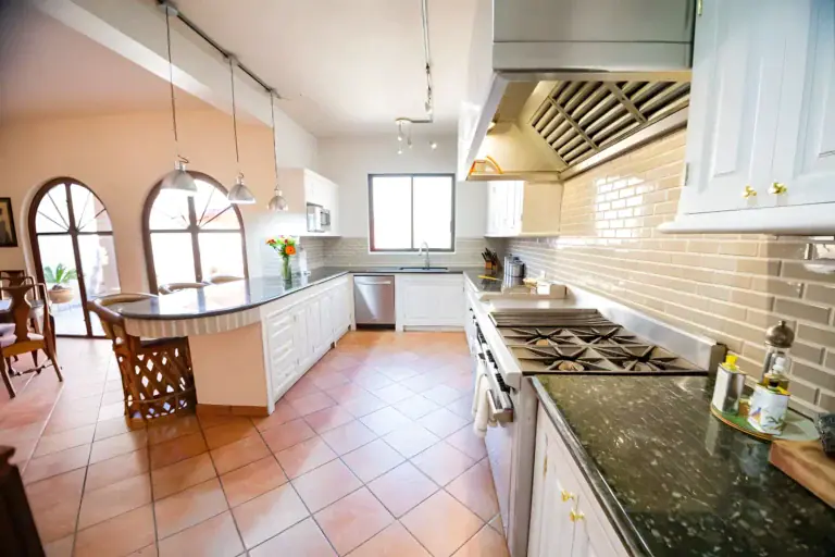 Casa Winston, kitchen with white cabinets, a green granite counter, a professional range and a subway tile wall, San Miguel de Allende
