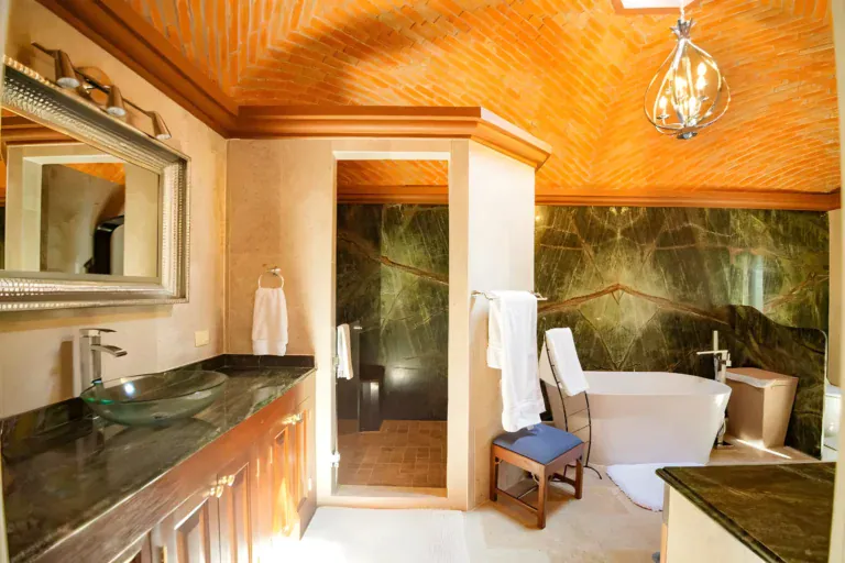 Casa Winston, bathroom with a freestanding tub, a green marble wall, a green granite vanity and a glass vessel sink, San Miguel de Allende