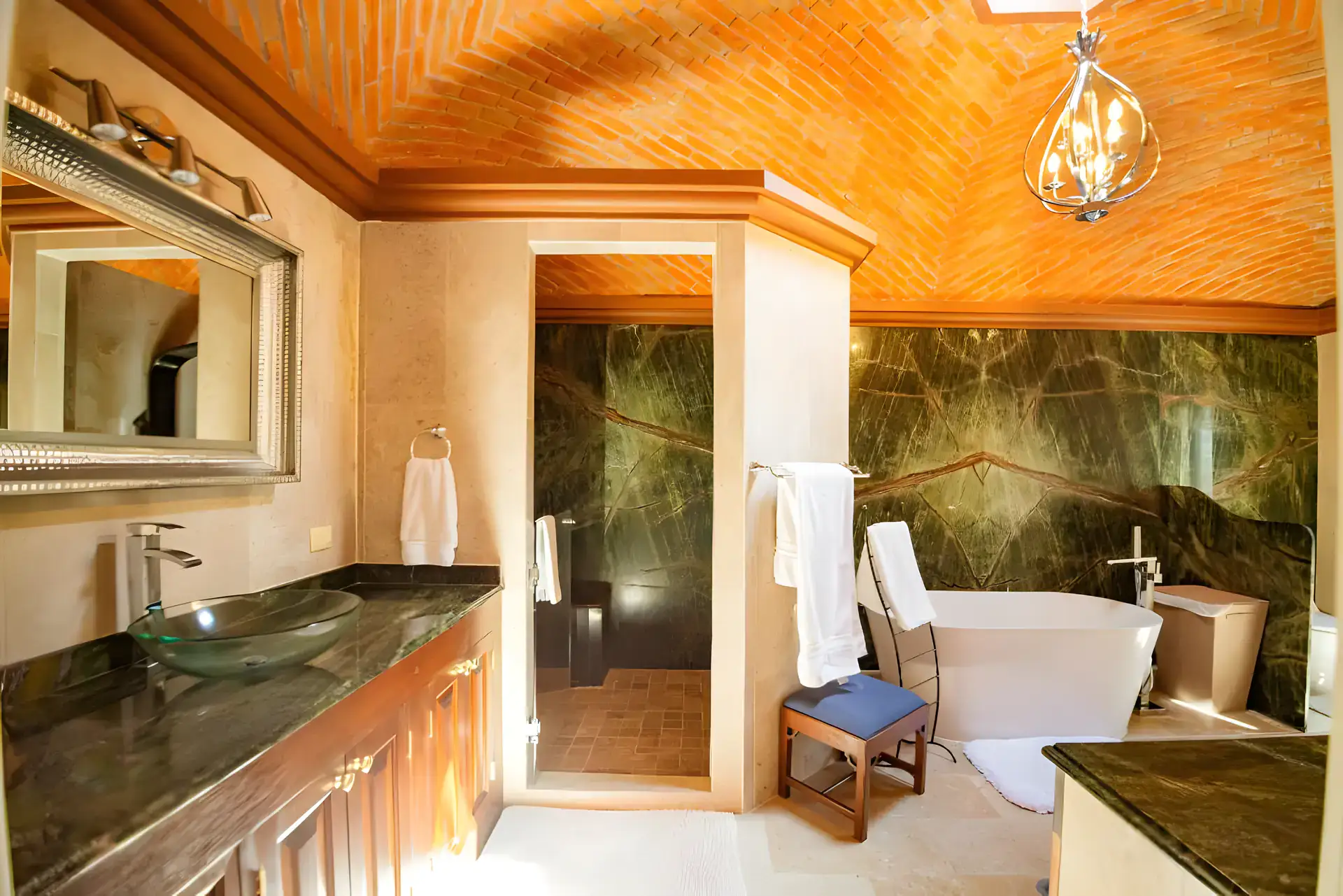 Casa Winston, bathroom with a freestanding tub, a green marble wall, a green granite vanity and a glass vessel sink, San Miguel de Allende