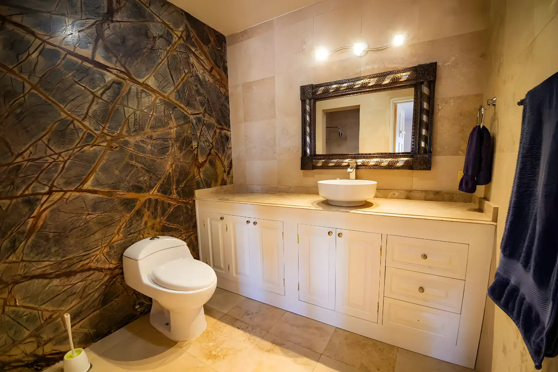 Casa Winston, bathroom with a green marble wall, a vessel sink on a cream vanity, a mirror and a toilet, San Miguel de Allende