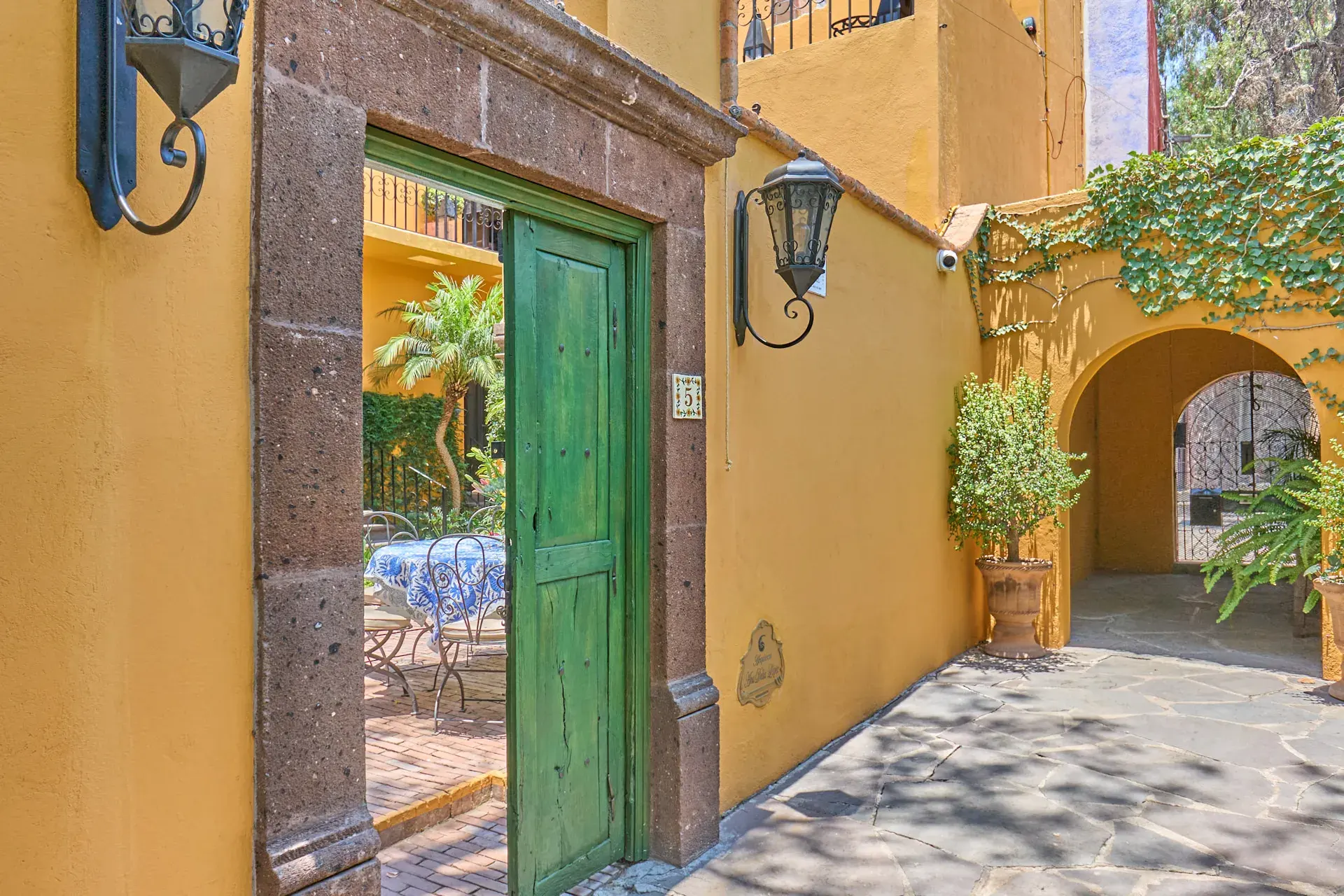 Casa Zaca, yellow entrance with a green door and a stone frame, San Miguel de Allende