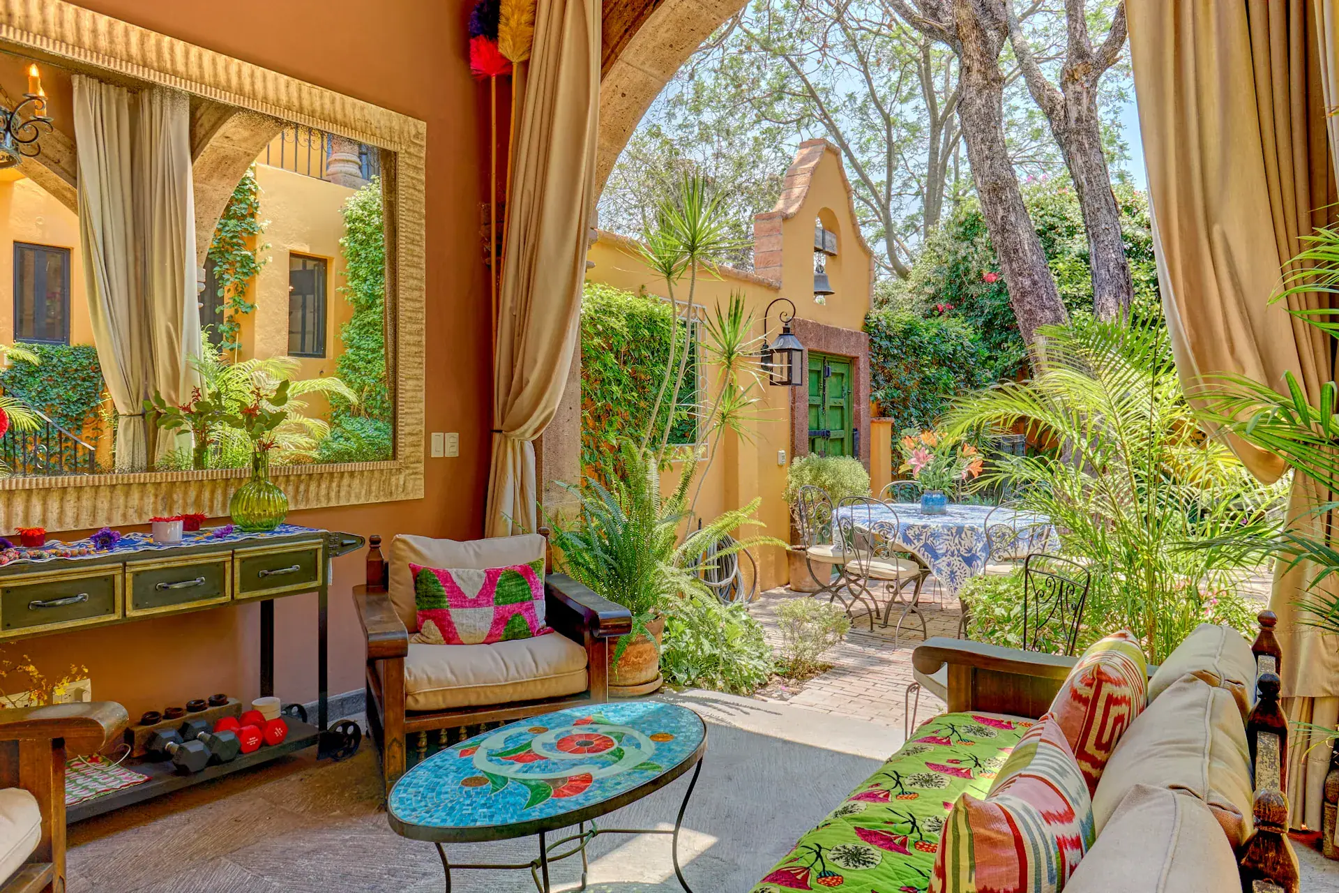 Casa Zaca, covered garden lounge with outdoor sofas and a cushioned bench, San Miguel de Allende