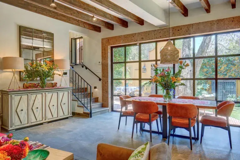 Casa Zaca, dining table with orange chairs and floor-to-ceiling glass doors, San Miguel de Allende