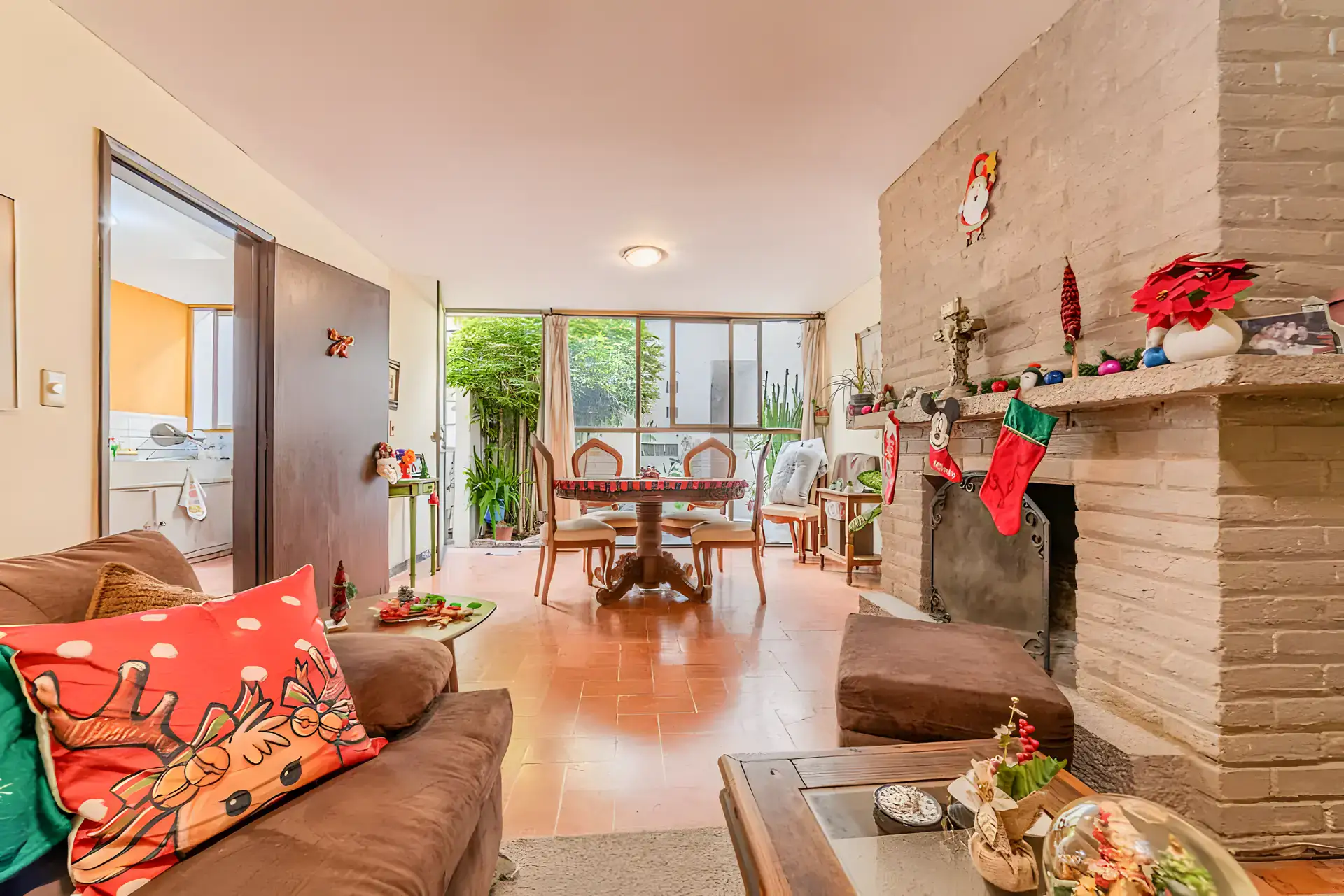 Casitas Terraplen, living room with a brick fireplace, a green lattice cabinet and a view to the dining area and a bedroom beyond, San Miguel de Allende
