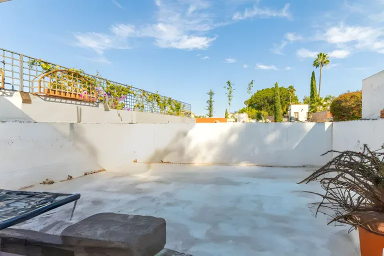 Casitas Terraplen, empty concrete roof terrace with white walls and a vine-covered trellis, San Miguel de Allende
