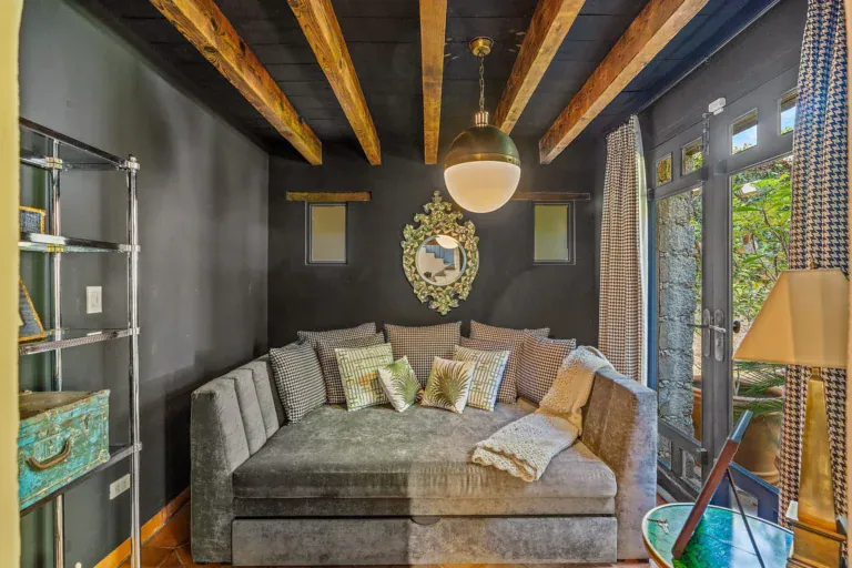 Cuesta de San Jose 22, den with a gray velvet daybed, a black wall, a round gold mirror and a glass door to the garden, San Miguel de Allende