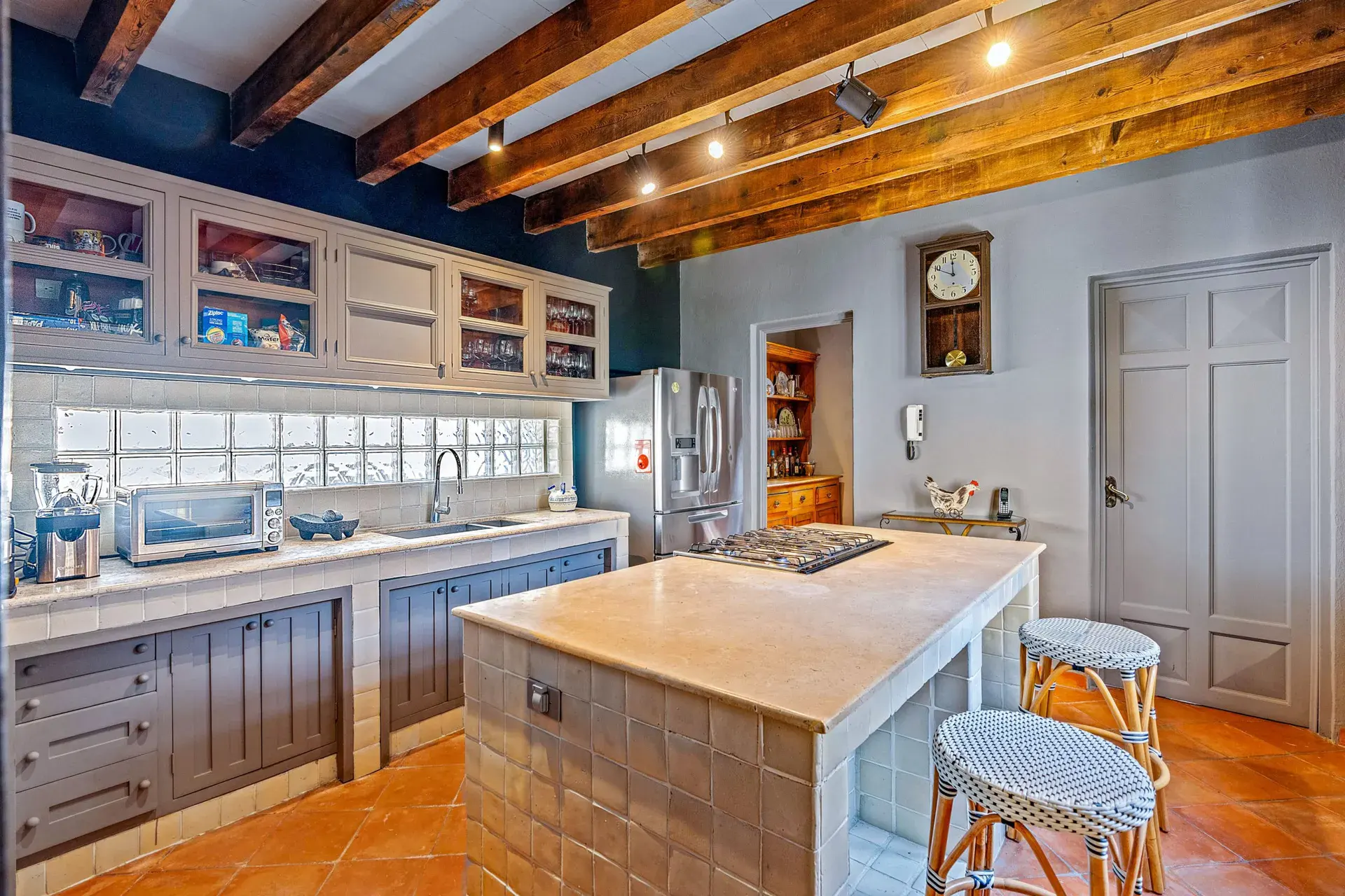 Cuesta de San Jose 22, kitchen with a tile island with a gas cooktop, striped bar stools, gray cabinets and a timber ceiling, San Miguel de Allende
