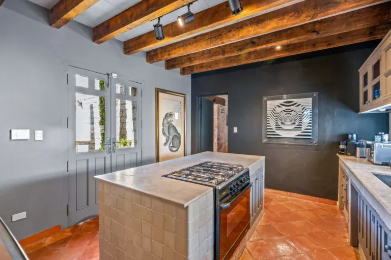 Cuesta de San Jose 22, kitchen with a black wall, a gas range, a tile island and French doors to the garden, San Miguel de Allende