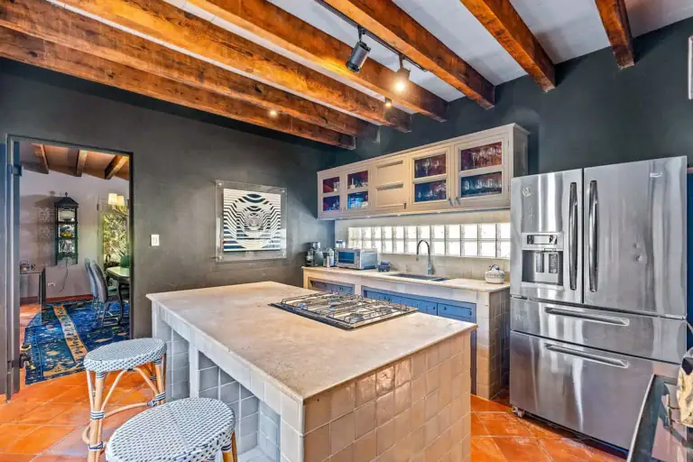 Cuesta de San Jose 22, kitchen with a stainless refrigerator, gray cabinets, a tile island and a view to the dining room, San Miguel de Allende