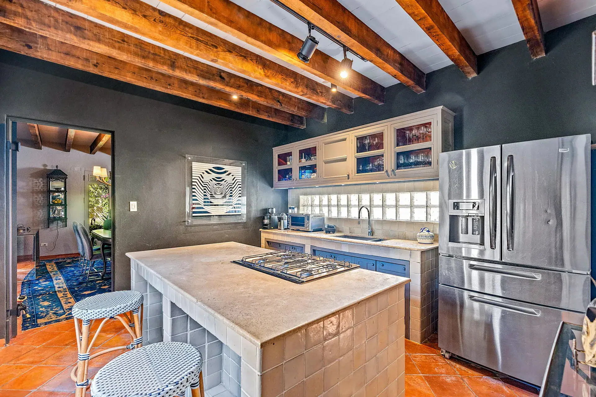 Cuesta de San Jose 22, kitchen with a stainless refrigerator, gray cabinets, a tile island and a view to the dining room, San Miguel de Allende