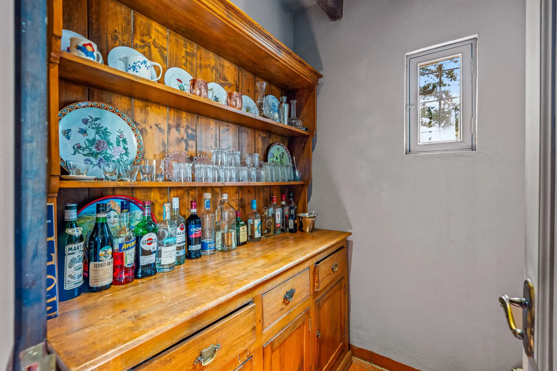 Cuesta de San Jose 22, butler's pantry with a wood hutch of china and a counter with bottles, San Miguel de Allende