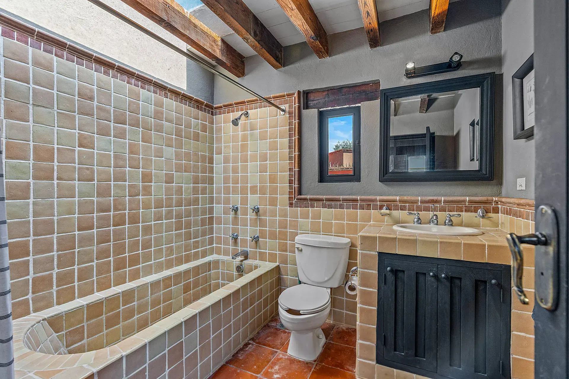 Cuesta de San Jose 22, bathroom with a tiled tub, a tile vanity with a black cabinet and a skylight, San Miguel de Allende