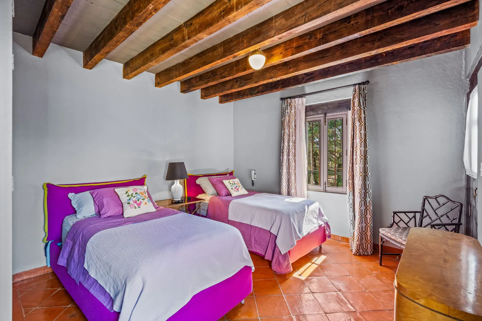 Cuesta de San Jose 22, guest bedroom with twin beds with purple bedding, a window with curtains and a timber ceiling, San Miguel de Allende