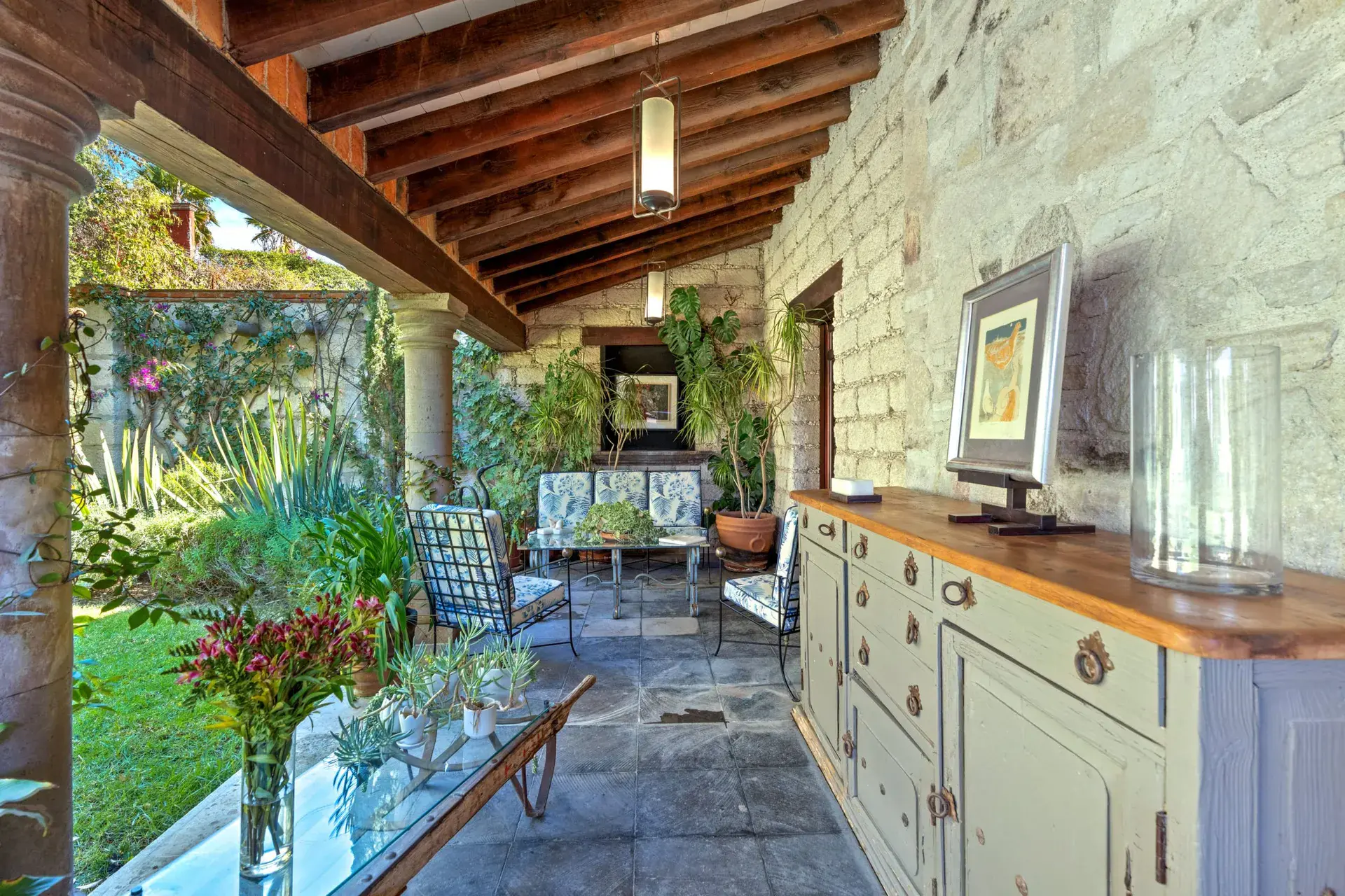 Cuesta de San Jose 22, covered terrace with an iron lounge set, a grey sideboard and a view of the garden, San Miguel de Allende