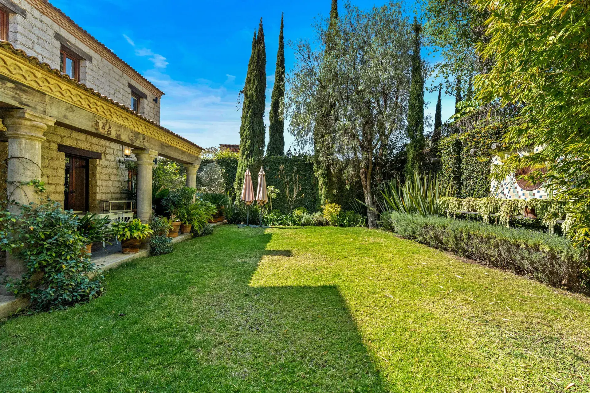 Cuesta de San Jose 22, lawn with cypress trees, hedges and the stone arcade of the house, San Miguel de Allende