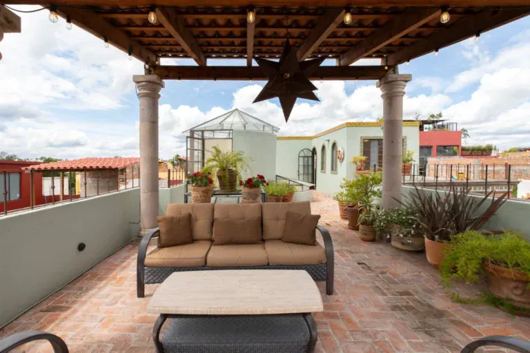 Casa Brillante, covered roof terrace with outdoor sofa and potted plants, San Miguel de Allende