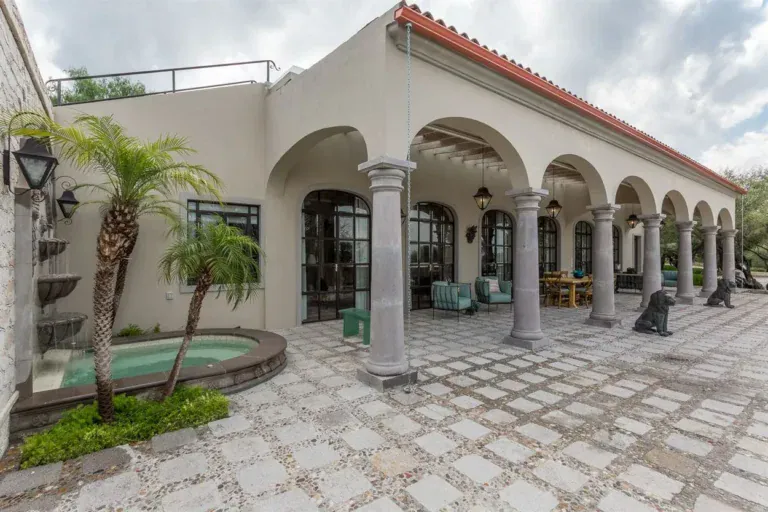 Finca Garambullos, arched colonnade facing a stone paved courtyard with a small pool, San Miguel de Allende