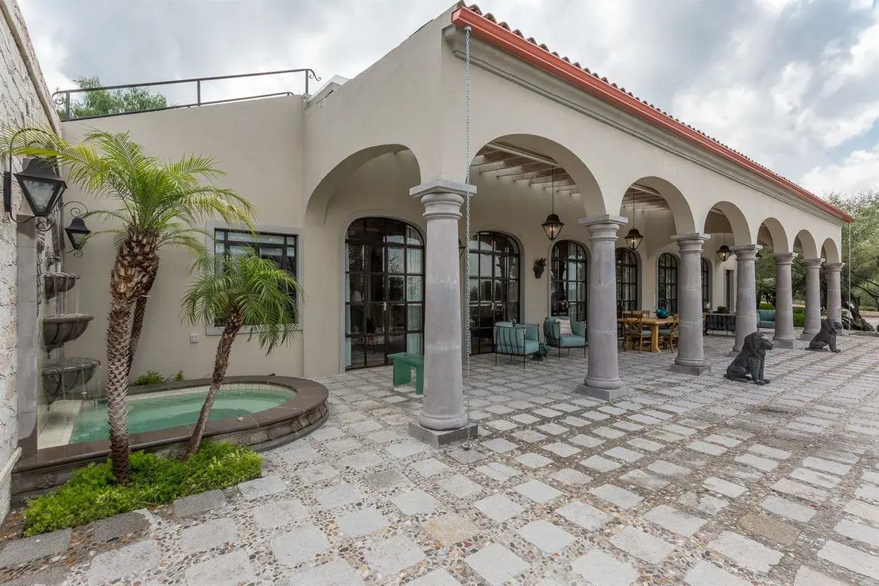 Finca Garambullos, arched colonnade facing a stone paved courtyard with a small pool, San Miguel de Allende